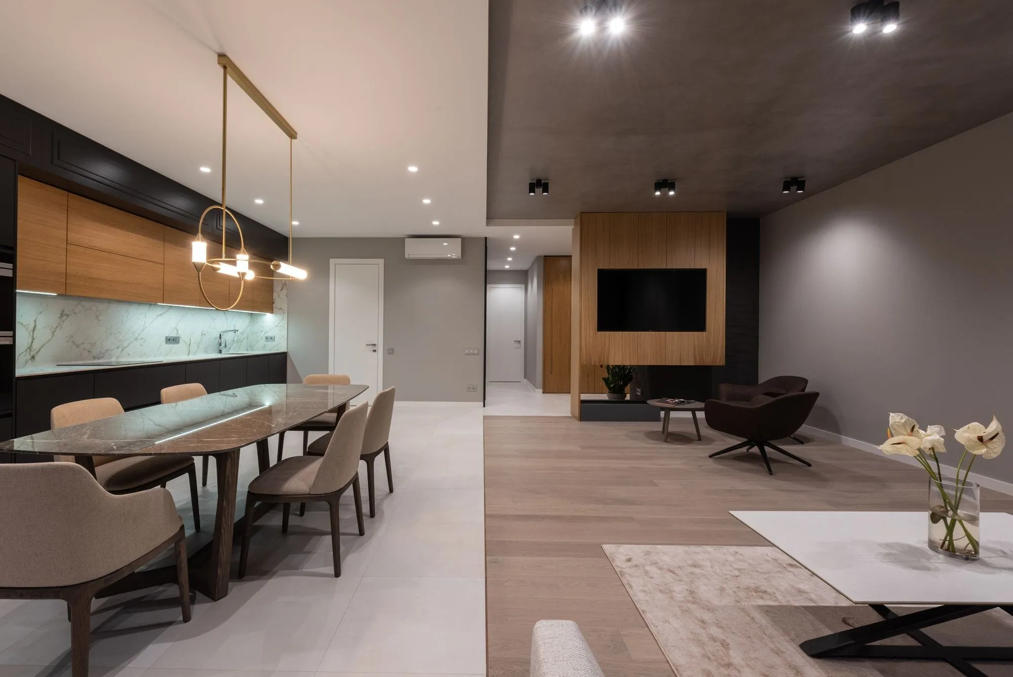 Open-plan dining room beside a dark timber kitchen
