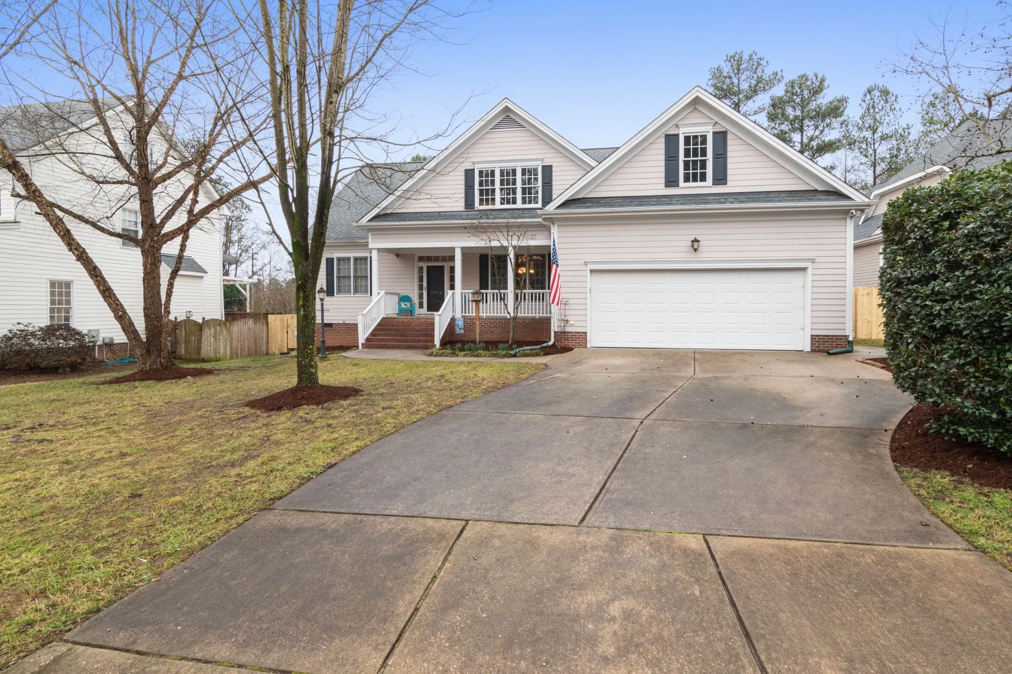 White cottage with a front porch and a garage